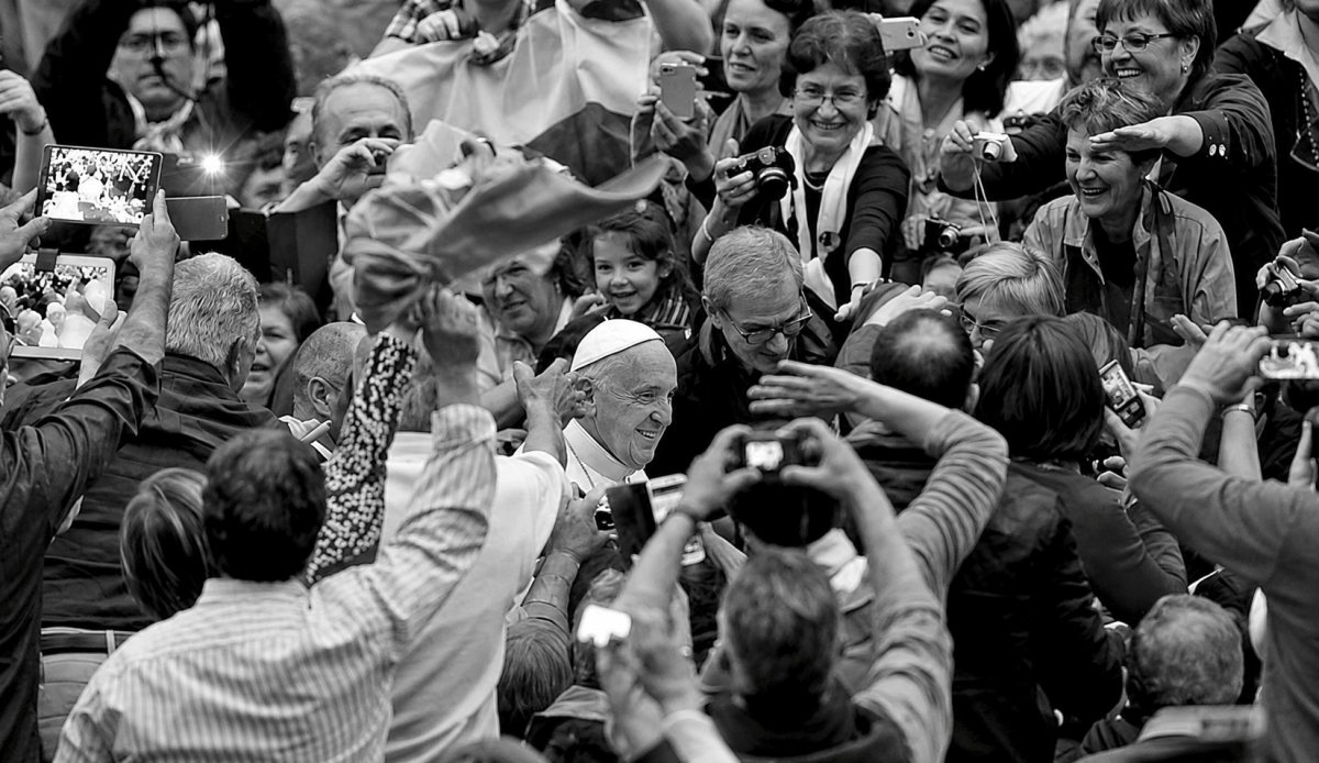 Papa Francisco rodeado por fiéis, sinal de proximidade pastoral.